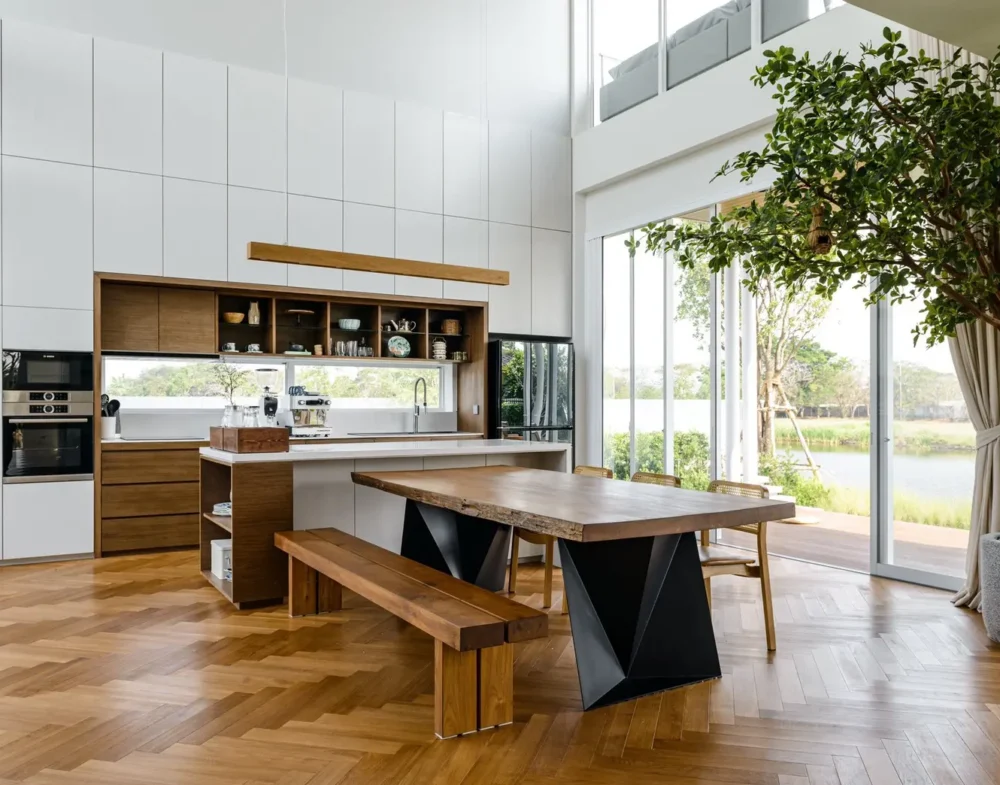 ห้องรับประทานอาหารเพดานสูง ปูพื้นไม้จริงลายก้างปลา (Herringbone) เข้ากับโต๊ะไม้สัก