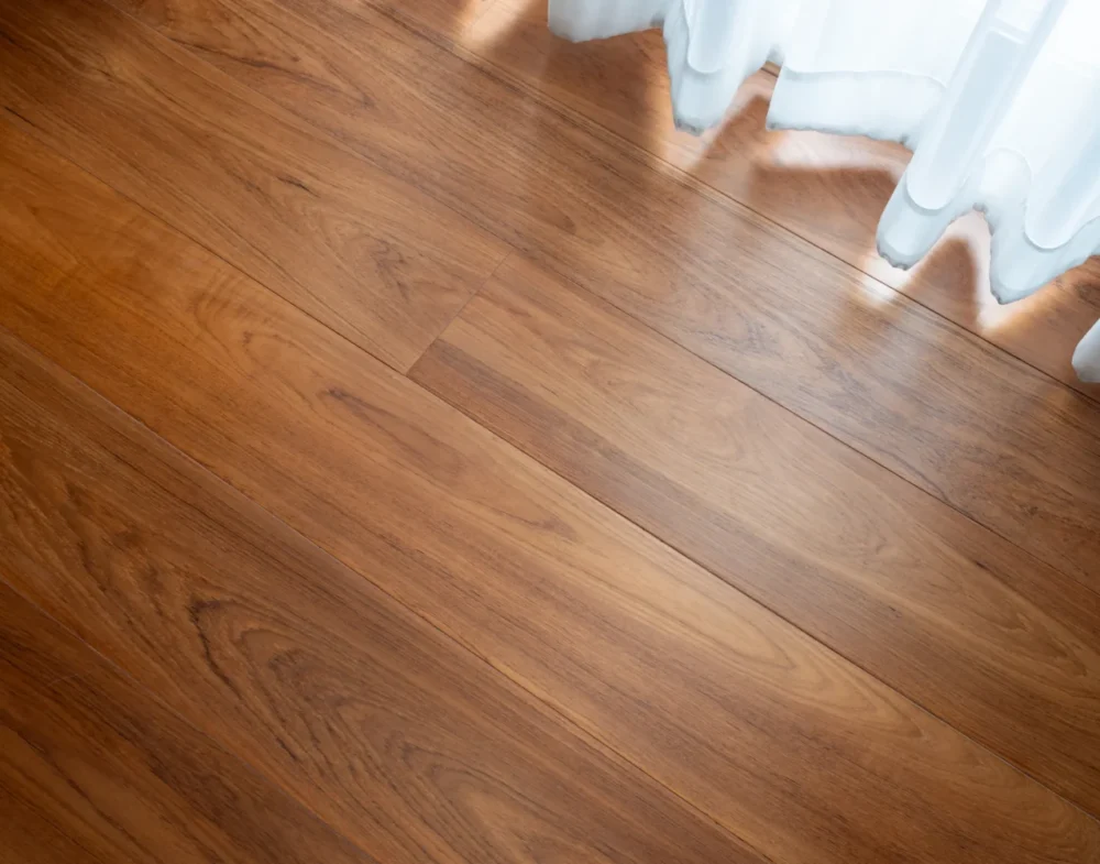 ลายไม้สักพม่า ดีไหม? ภาพระยะใกล้ของพื้นไม้สักสีน้ำตาลทอง ลายไม้สวยงามและเสี้ยนไม้ตรง เห็นรอยต่อไม้ชัดเจน